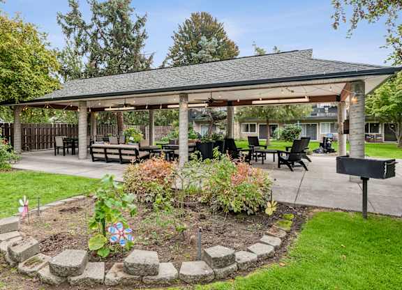 A gazebo is surrounded by a circular garden with a mailbox on the right.