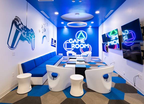 A game room with a blue and white color scheme and a variety of gaming equipment.