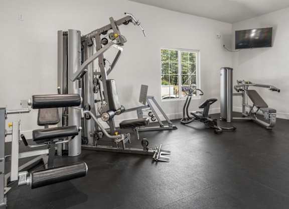 A well equipped home gym with a television.
