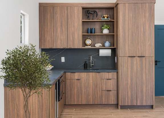 A kitchen with wooden cabinets and a black countertop.