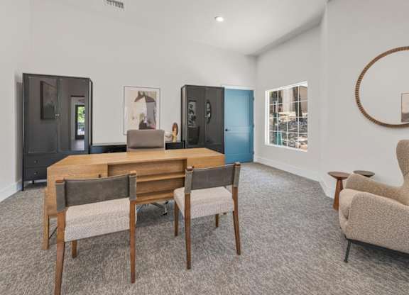 A room with a wooden table and chairs, a round mirror, and a framed picture on the wall.