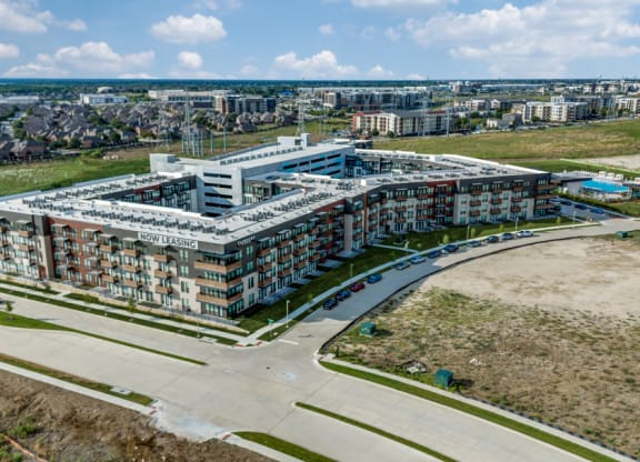 an aerial view of a building with a city in the background