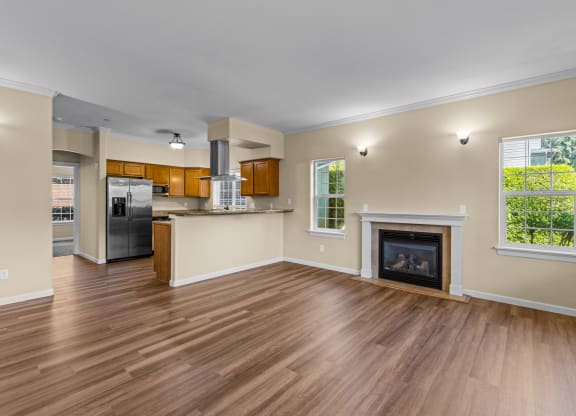 Little Tuscany Apartments & Townhomes - Living Room with Fireplace, Breakfast Bar, Kitchen with Stainless Steel Appliances, Wood Plan Vinyl Flooring, White Woodwork