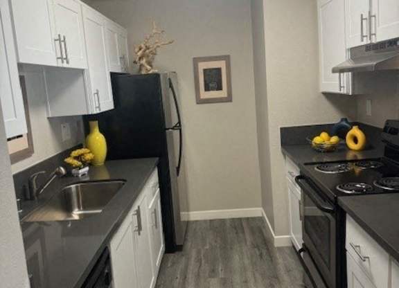 a kitchen with white cabinets and stainless steel appliances