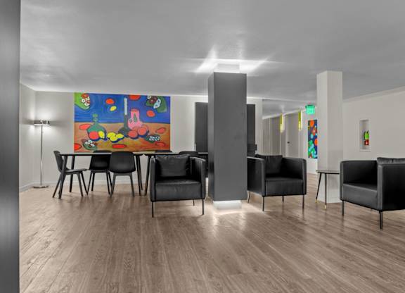 A room with a wooden floor and a large painting on the wall.
