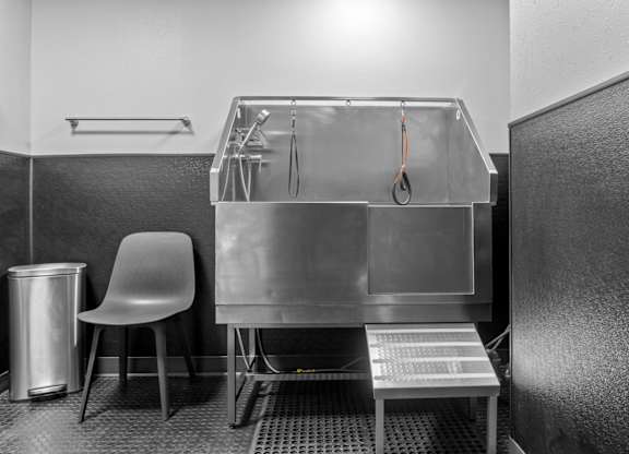A clean, empty kitchen with a sink and a chair.