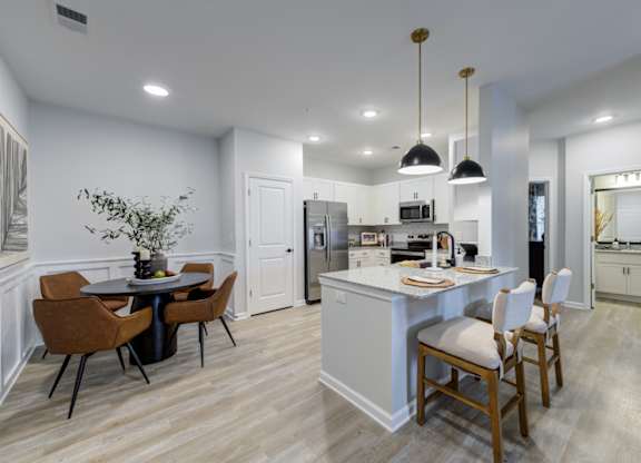 A modern kitchen with a dining table and chairs.