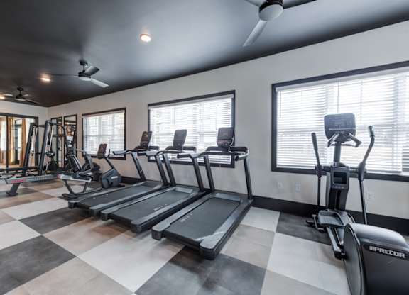 A gym with treadmills and elliptical machines.