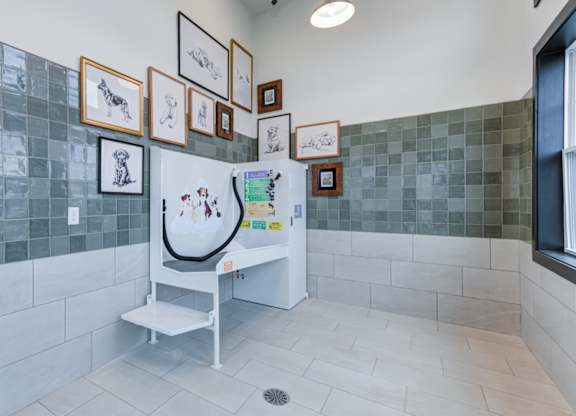 A kitchen with a fridge and pictures on the wall.