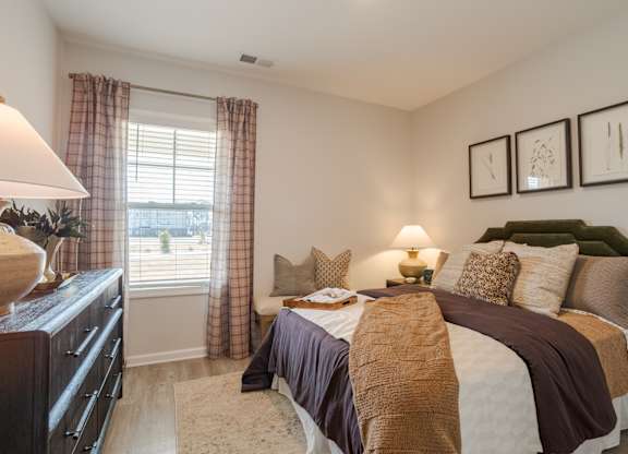 A bedroom with a large bed and a dresser.