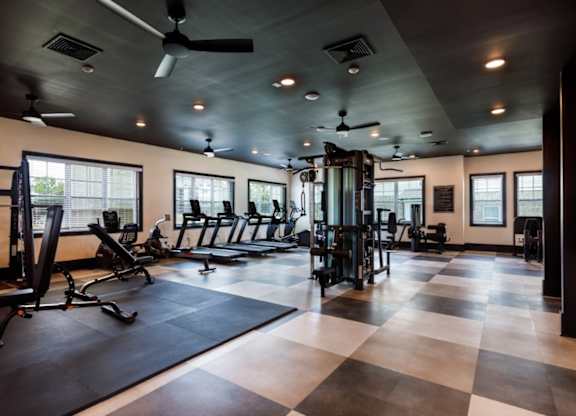 A spacious gym with a variety of equipment and a checkered floor.
