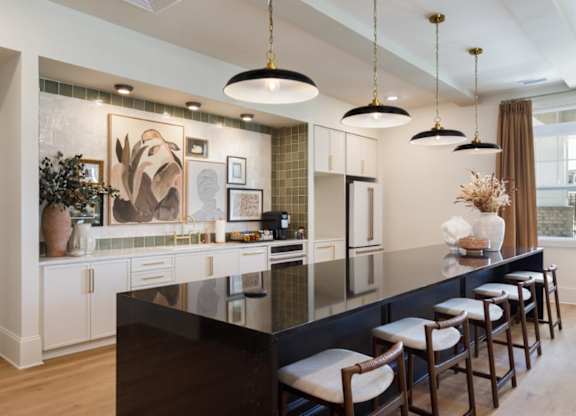 A kitchen with a black countertop and white cabinets.