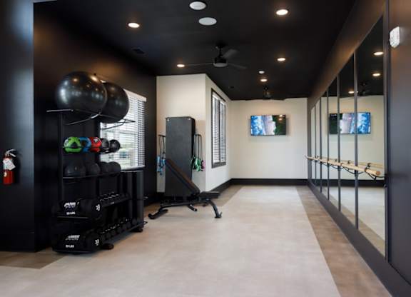 A gym with a row of mirrors on the wall.