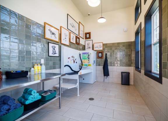 A bathroom with a tiled wall and a white sink.