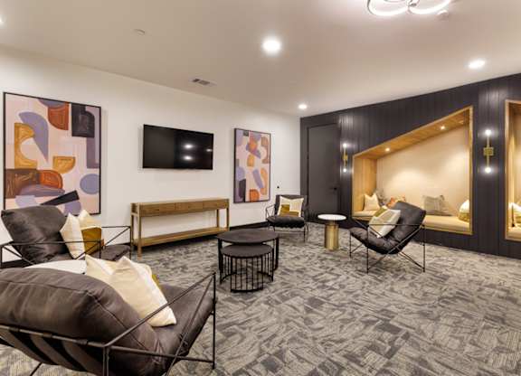 A living room with a grey carpet and a wooden bench.