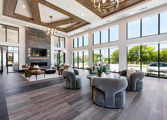 A modern living room with a stone fireplace and a large window.