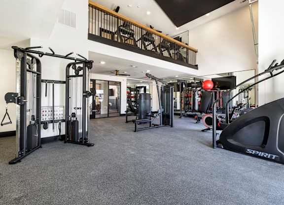 A gym with a variety of equipment including a rowing machine.