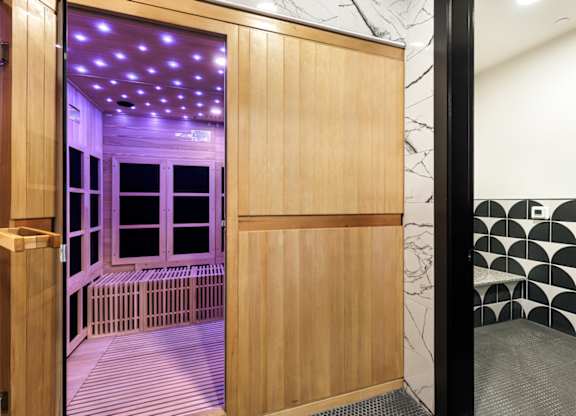 A room with a wooden door and a black and white tiled wall.