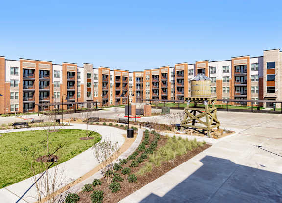 A large building complex with a fountain in the middle of a courtyard.