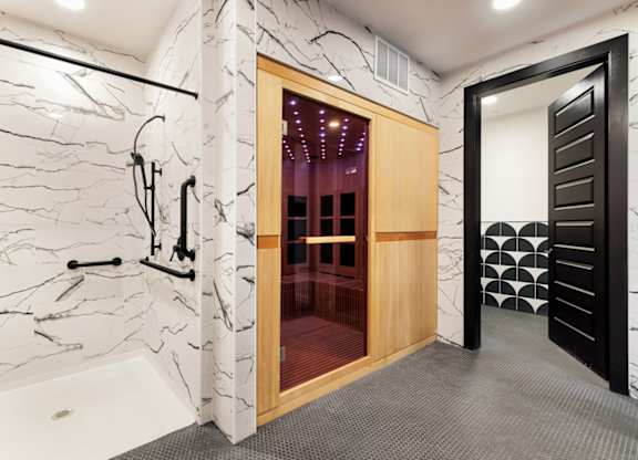 A bathroom with a marble wall and a wooden door.