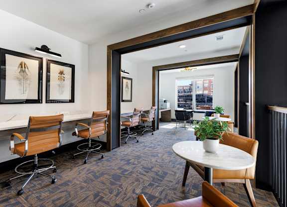 A conference room with a table, chairs, and framed pictures on the wall.