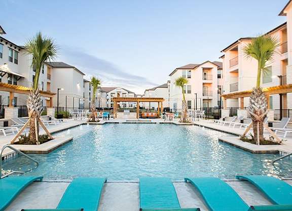 The Flats at Shadowglen Apartments in Manor, TX Pool with Lounge Chairs