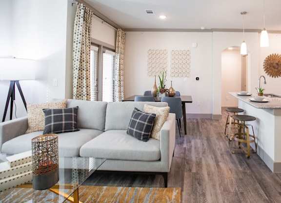 The Flats at Shadowglen Apartments in Manor, TX Model Living Room and Kitchen