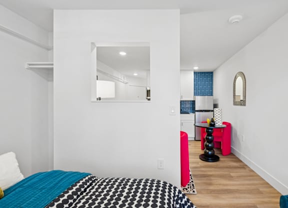A bedroom with a bed and a mirror on the wall.