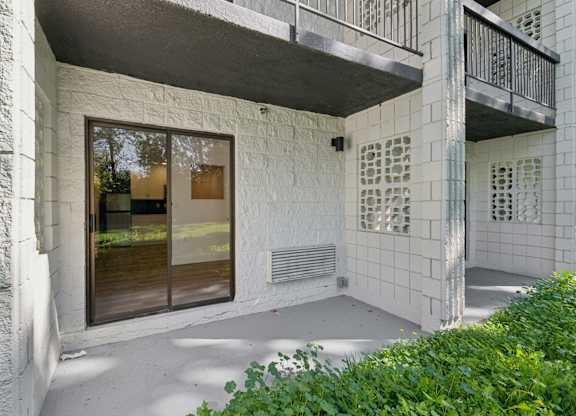 A white building with a balcony and a door.