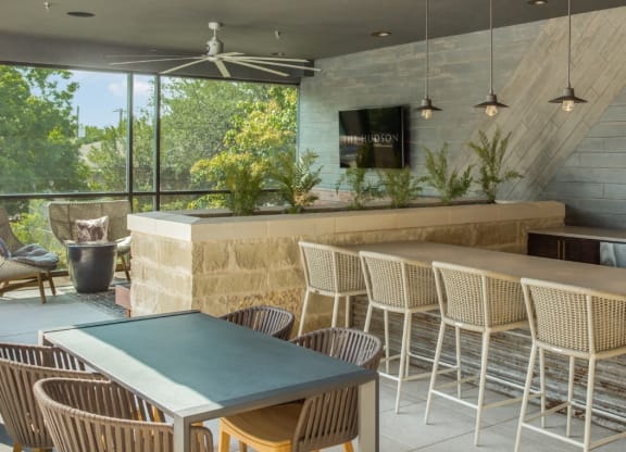 a patio with a table and chairs and a bar