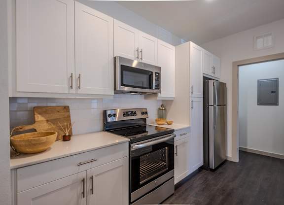 A kitchen with white cabinets and stainless steel appliances.