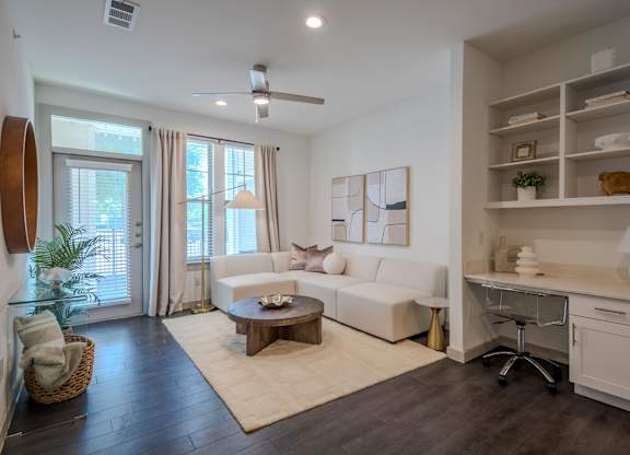 A living room with a white couch and a wooden coffee table.