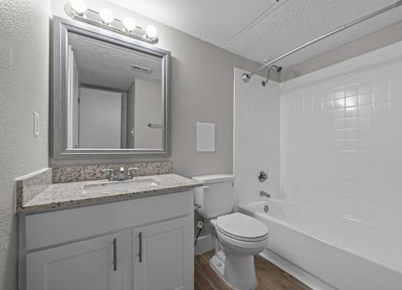A bathroom with a white toilet, sink, and bathtub.