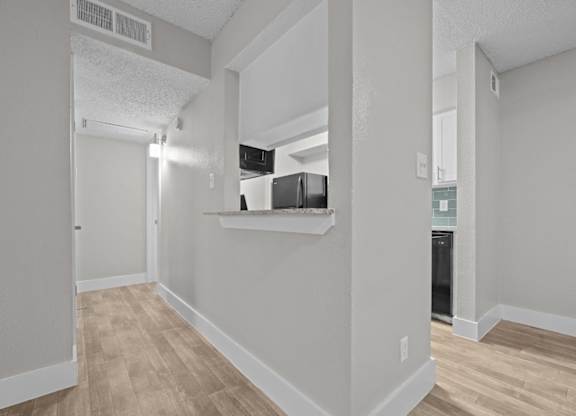 A kitchen area with a refrigerator, microwave, and oven.