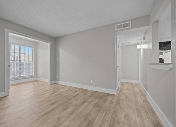A room with wooden flooring and white walls.