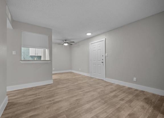 A room with a wooden floor and a ceiling fan.