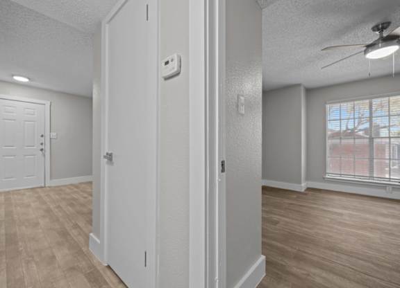 A room with a white door and a window with a view of a building outside.