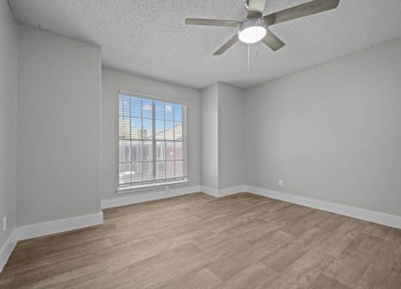 Empty room with a ceiling fan and a window.