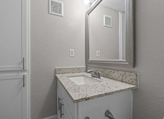 A bathroom with a sink and mirror.