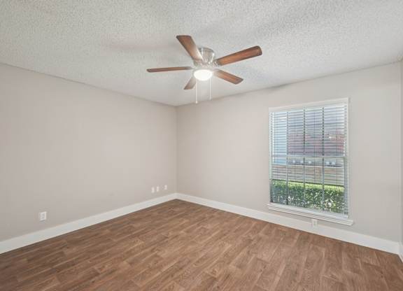 Empty room with a ceiling fan and a window.