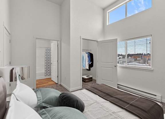 A bedroom with a bed and a window with blinds.