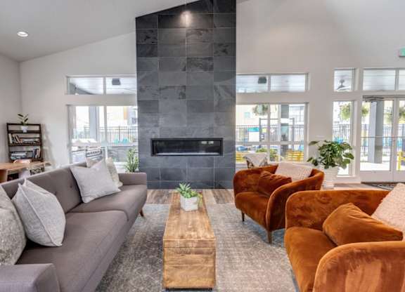 A living room with a grey couch, a wooden coffee table, and a fireplace.