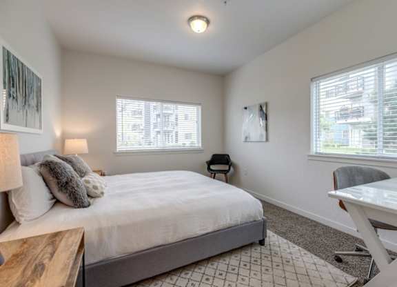 A bedroom with a bed, desk, and chair.