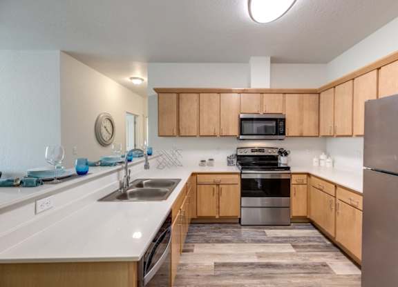 A kitchen with wooden cabinets and a stainless steel refrigerator.