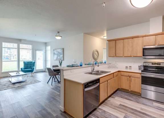 A kitchen with wooden cabinets and a stainless steel dishwasher.