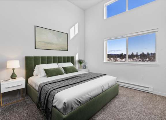 A bedroom with a large bed and a window showing a snowy landscape outside.
