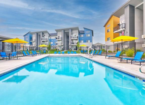 A large swimming pool in front of apartment buildings.