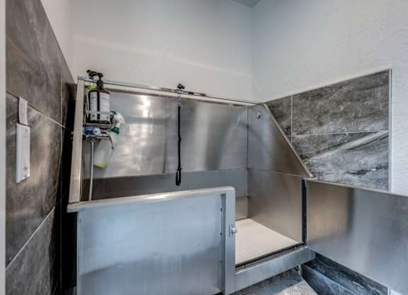 A stainless steel kitchen with a sink and a door.