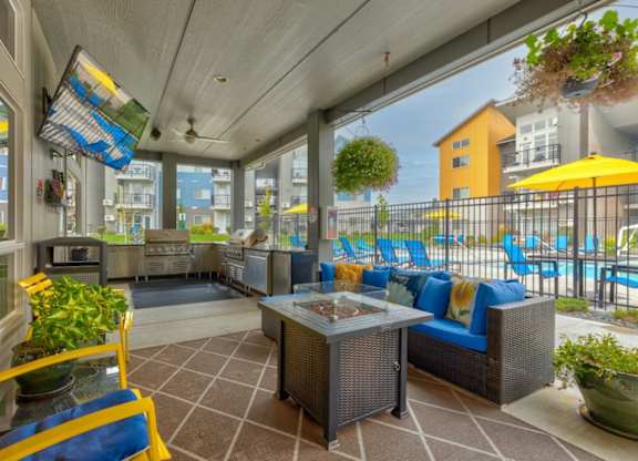 A patio with a table and chairs overlooking a pool.