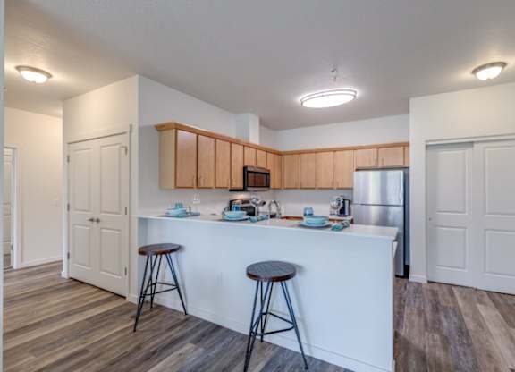 A kitchen with white countertops and wooden cabinets.